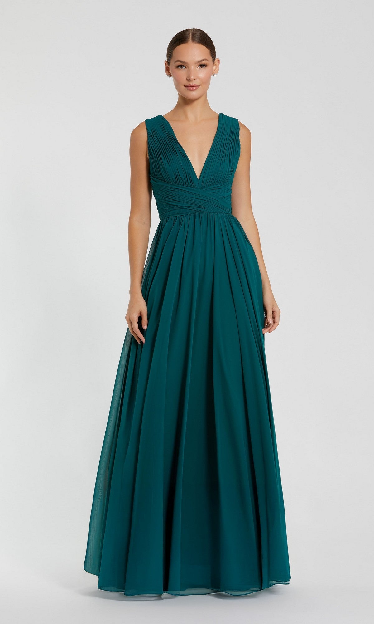 A woman poses against a plain light background in a teal Mac Duggal 11585 long formal dress featuring a sleeveless design, deep V-neckline, and pleated bodice.